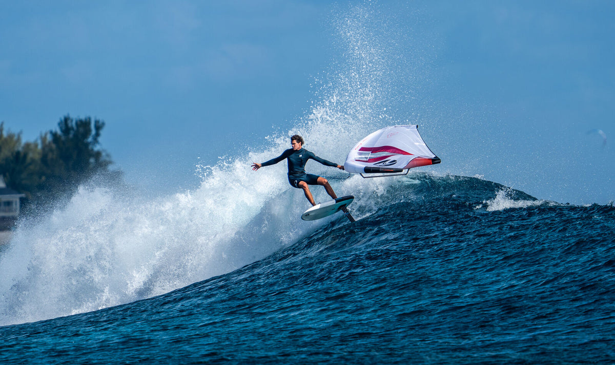 Wing foiler carving a wave on the Cabrinha Domani foil