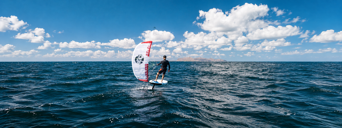 Rider using a Cabrinha Nomad parawing to glide above the water on a hydrofoil board.