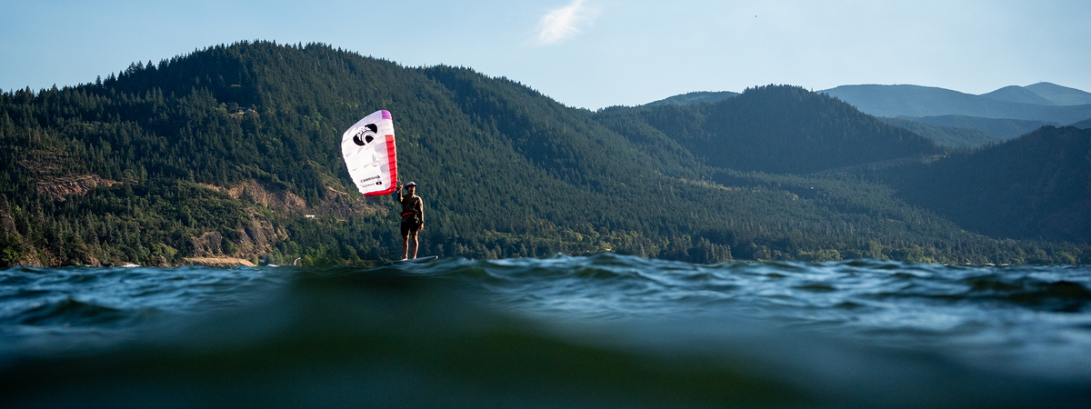 Parawing rider foiling across the water with a Cabrinha Nomad parawing.